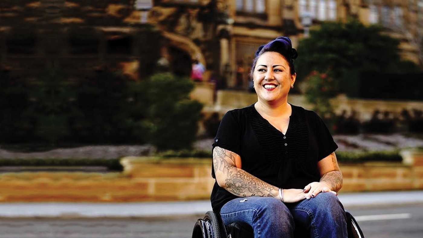 Heidi is in a wheelchair sitting outside.