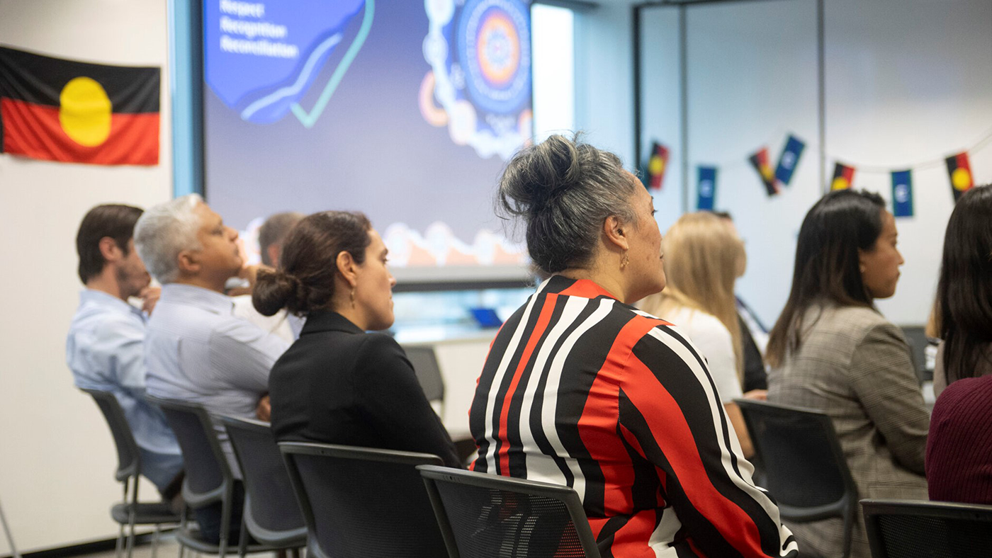 Photo of Moana Rangi sitting with other colleagues in an icare office at a First Nations Working Group event.