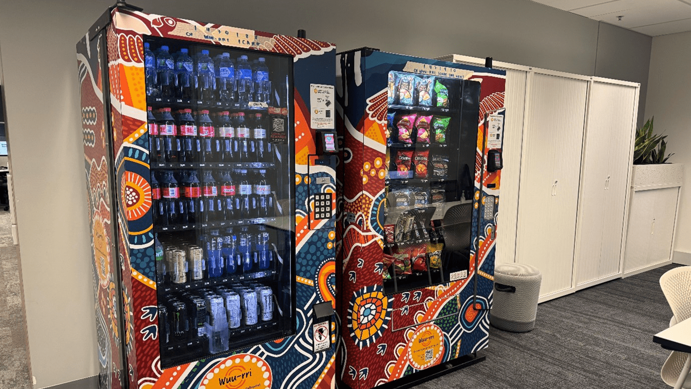 Photo of two Wuu-rri vending machines in an icare office, featuring First Nations artwork.