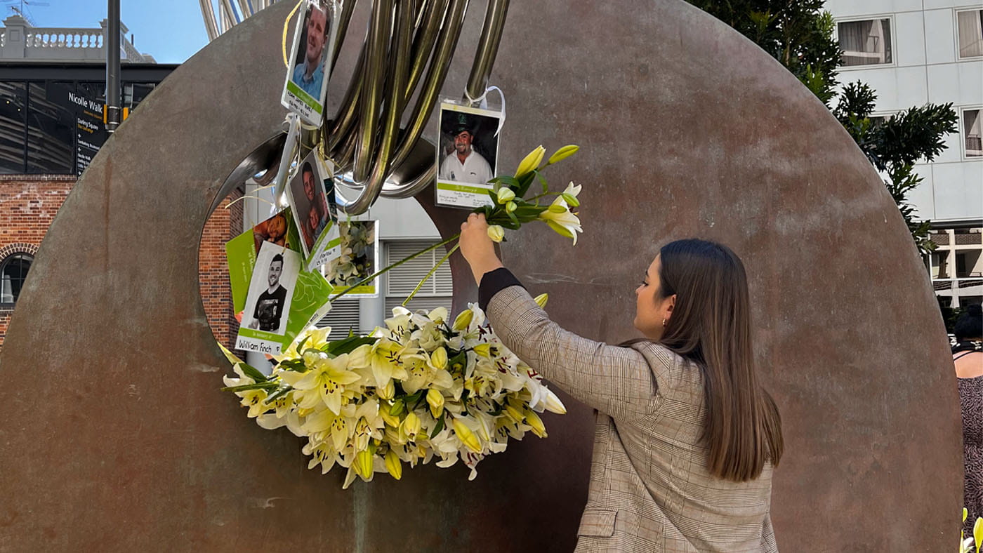 Women placing flowers in mourning monument