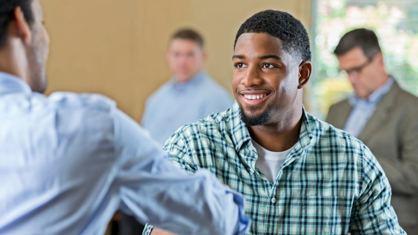 Smiling man shaking hands with another man