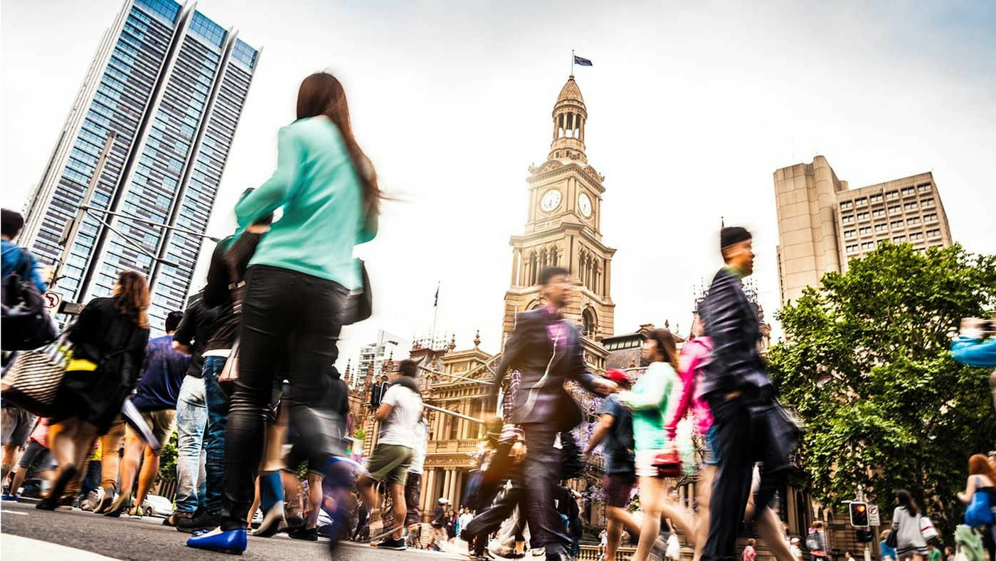 Busy people walking in city with tall buildings
