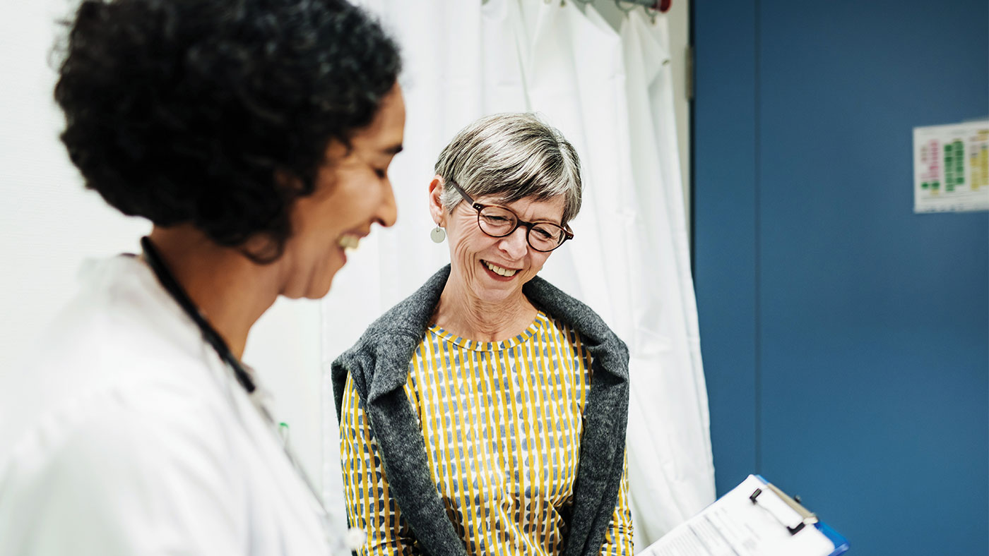 female doctor smiling with elderly female patient