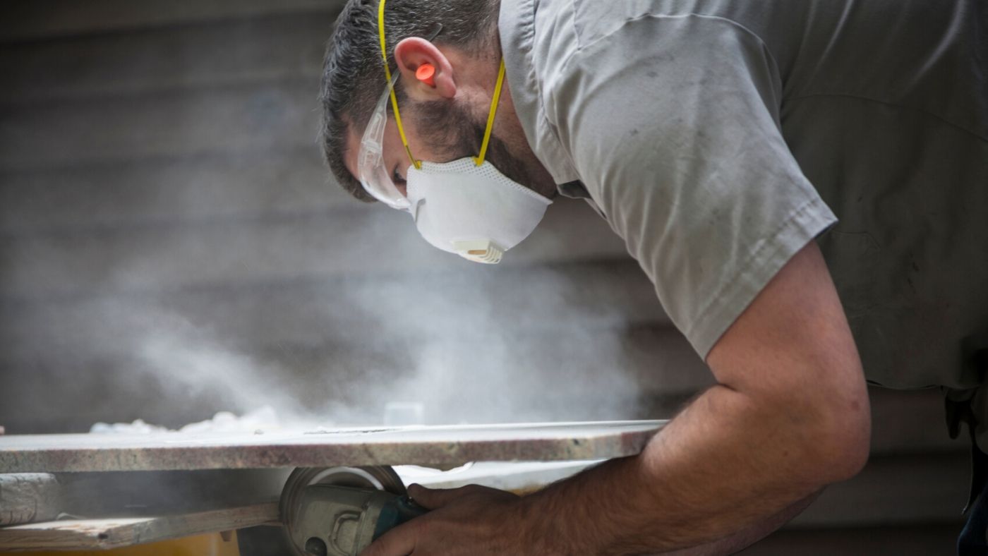 Tradesman grinding stone with a mask on