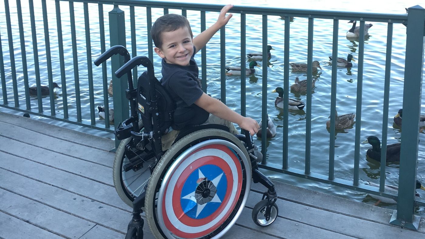 loop plus boy in wheelchair feeding ducks 1400x788 Young boy, Evander, sitting in his wheelchair by a pond feeding ducks