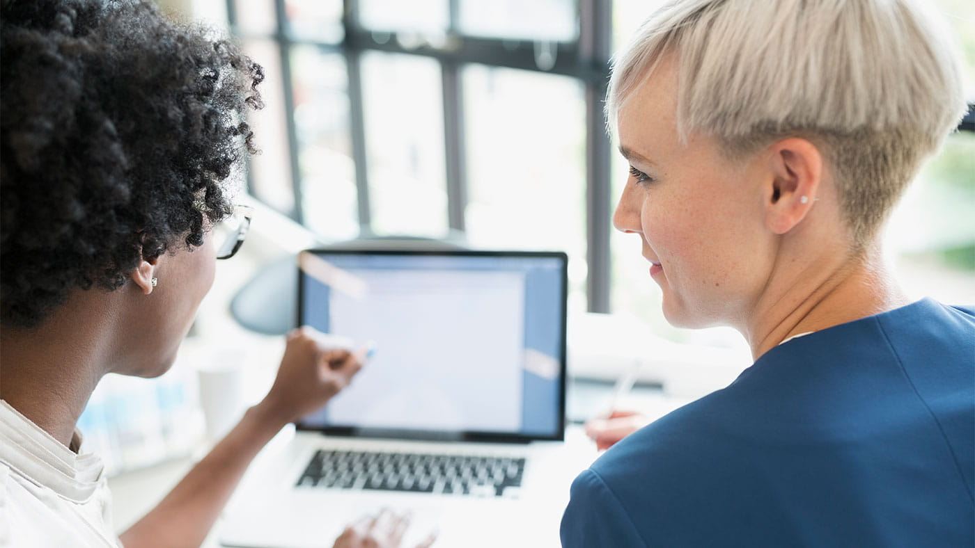 Two business women working at a laptop