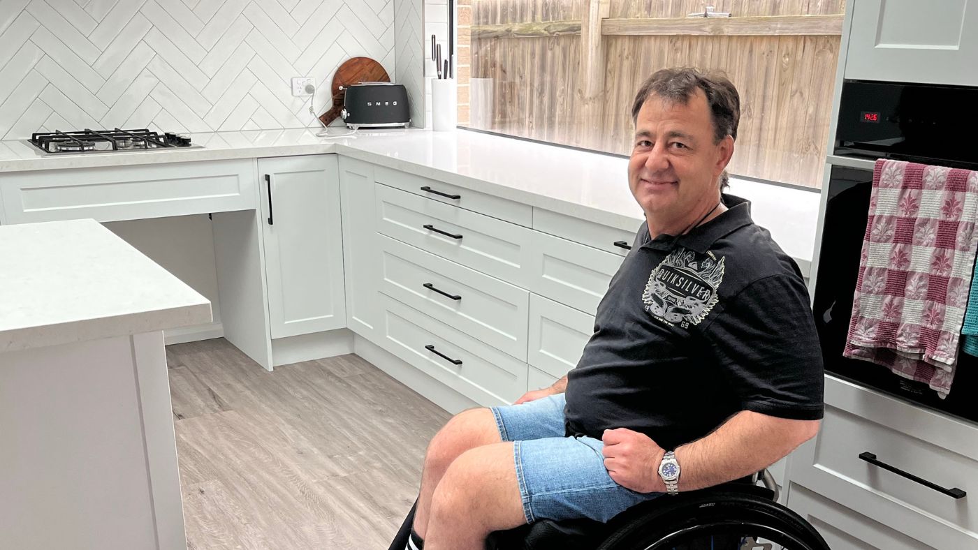 Jason sitting in his wheelchair in his kitchen