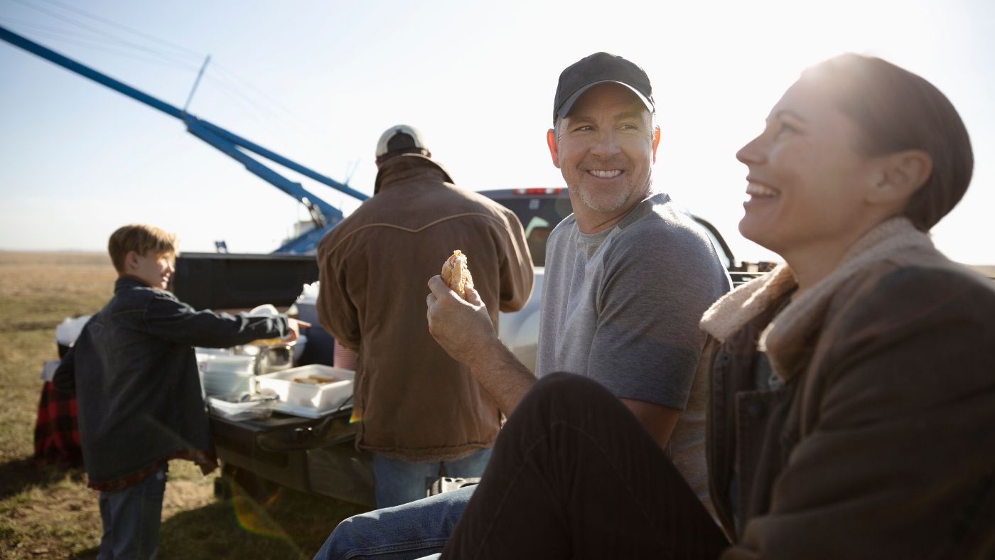 People on a farm eating lunch and laughing on a farm